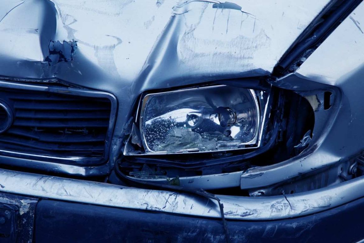 Gros plan sur l'avant d'une voiture grise fortement endommagée après un accident, illustrant l'importance de réduire le coût de son assurance auto tout en restant bien couvert.